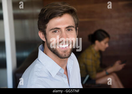 Portrait of a businessman smiling with his colleague in the background Stock Photo