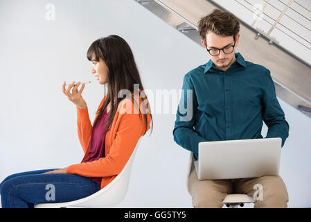 Two business people busy in different activities Stock Photo