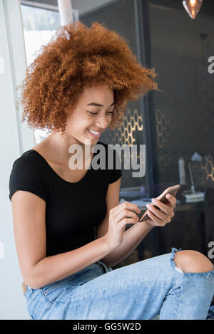 Happy young woman using a smart phone Stock Photo