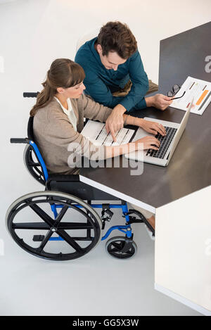 Two business people working on a laptop in an office Stock Photo