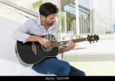 Mid adult man playing a guitar Stock Photo