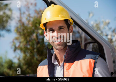 Portrait of a male engineer standing by van at site Stock Photo