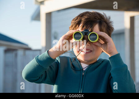 Boy looking through binoculars Stock Photo