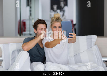 Young couple taking a selfie on the bed Stock Photo