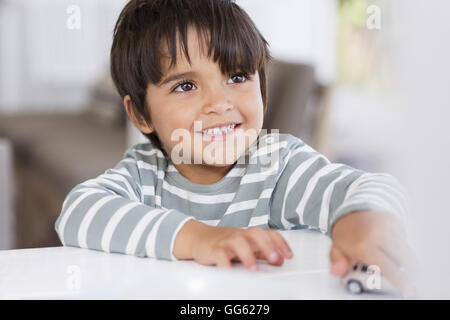 Boy playing with toy car in a living room Stock Photo