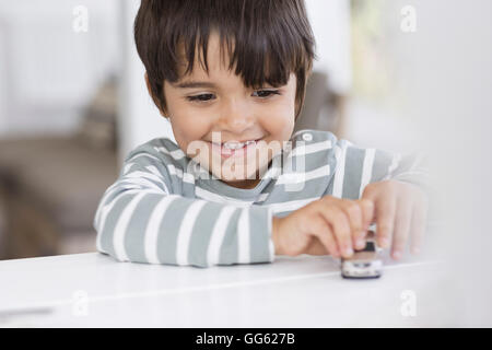 Boy playing with toy car in a living room Stock Photo