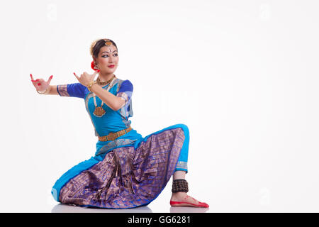 Full length of female dancer performing Bharatanatyam against white background Stock Photo