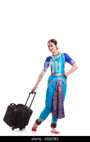 Full length of Bharatanatyam dancer with luggage over white background Stock Photo
