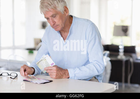 Senior man counting currency note son table Stock Photo