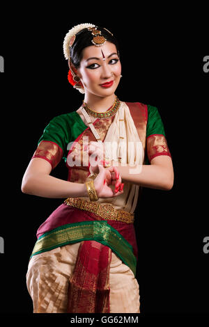 Beautiful woman performing Bharatanatyam on black background Stock Photo