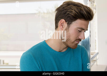 Close-up of a young man looking serious at home Stock Photo