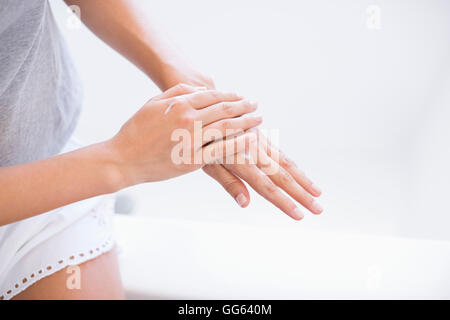 Close-up of a woman applying moisturizer on her hands Stock Photo