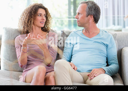 Happy couple talking on couch in a living room Stock Photo
