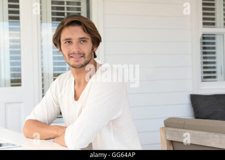 Happy young man sitting at home Stock Photo