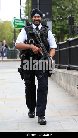 An armed Sikh police officer patrols as part of a security operation near the junction of Knightsbridge and Hyde Park Corner, London, as Scotland Yard announced that the first of 600 additional armed officers were trained and operationally ready, and unveiled plans to put more marksmen on public patrol. Stock Photo