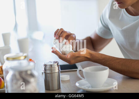 Close-up of a young man taking nutritional supplement pills Stock Photo