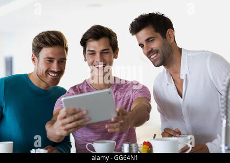 Close-up of three happy young men taking selfie with a digital tablet Stock Photo