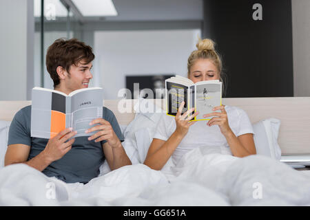 Young couple reading books on the bed Stock Photo