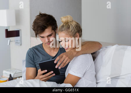 Couple using a digital tablet on the bed Stock Photo