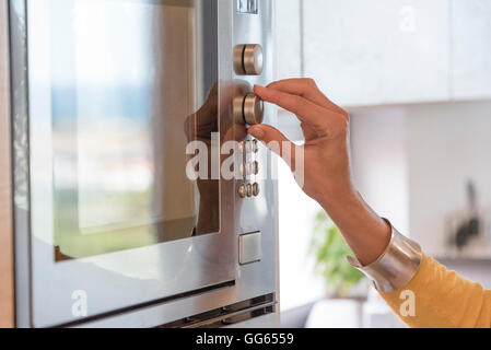 Close-up of a woman hand using an oven Stock Photo