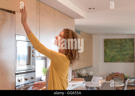 Side profile of a woman working in the kitchen Stock Photo
