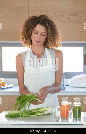 Young woman arranging fennels in the kitchen Stock Photo