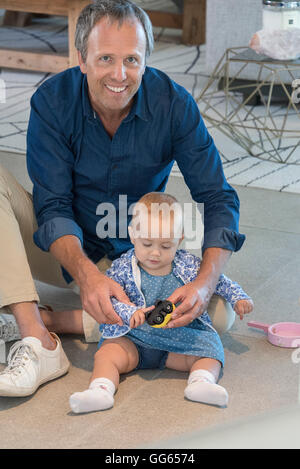 Portrait of a mature man playing with his baby daughter Stock Photo