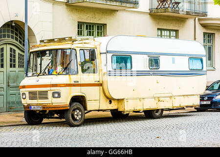 Ystad, Sweden - August 1, 2016: Old rusty truck rebuilt and fitted with a caravan trailer on the flatbed. One of a kind vintage Stock Photo