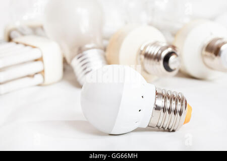 energy saving new LED lamp and many old incandescent light bulbs and used compact Fluorescent lamps Stock Photo