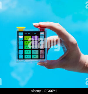 testing chlorine pollution in blue water of outdoor pool by chemical tester Stock Photo