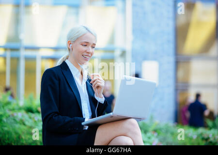 Businesswoman chatting in financial district Stock Photo