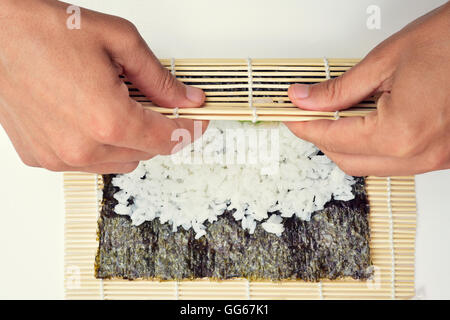 https://l450v.alamy.com/450v/gg67k1/closeup-of-a-young-man-preparing-makizushi-rolling-a-bamboo-mat-with-gg67k1.jpg