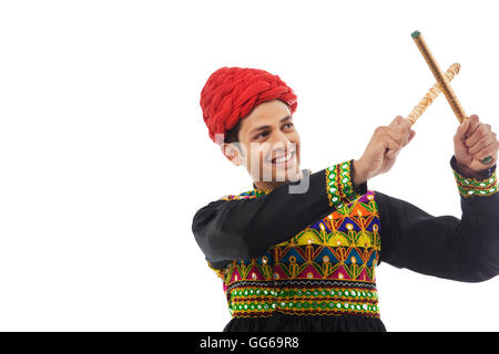 Male dandiya dancer dancing with sticks Stock Photo - Alamy