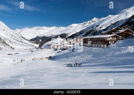 Groups of skiers enjoying the winter conditions with the village of Obergurgl and Otztal Alps beyond, Tyrol, Austria, Europe Stock Photo