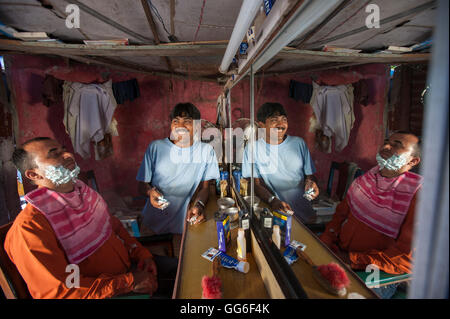 A hairdresser smiles for the camera in his little barbershop in Rishikesh, Uttaranchal, India, Asia Stock Photo