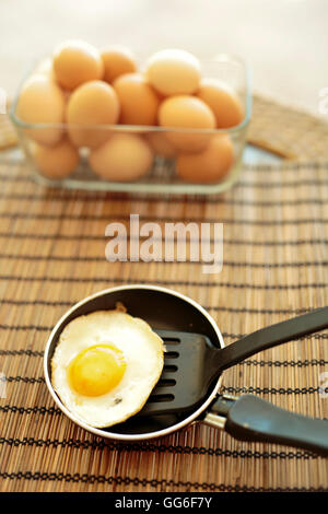 Fried egg in a small saucepan on a tablecloth Stock Photo