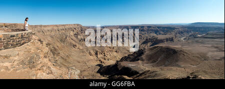 A woman looks into The Fish River Canyon in southern Namibia, Africa Stock Photo