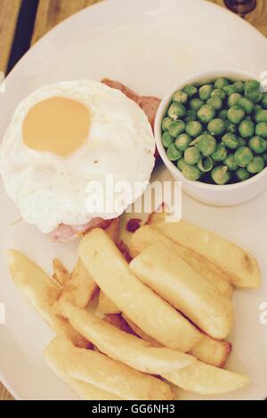 Gammon egg and chips with garden peas Stock Photo