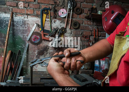 dirty hands of a worker who makes strength on a screw with a clamp Stock Photo