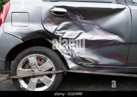 UK. A car with a badly dented rear door following a collision with another vehicle Stock Photo