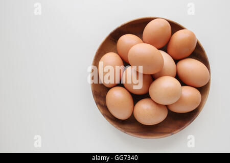 Eggs in wooden bowl on white copy space background Stock Photo