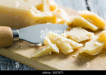 The parmesan cheese with knife on cutting board. Stock Photo