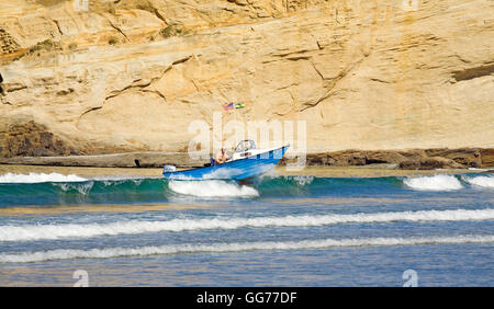 A dory boat lands on the beach at high speed in Pacific City, Oregon, home of the Pacific City Dory Fleet. Pacific City is one o Stock Photo