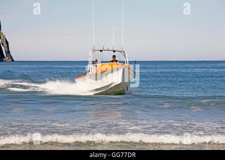 A dory boat lands on the beach at high speed in Pacific City, Oregon, home of the Pacific City Dory Fleet. Pacific City is one o Stock Photo