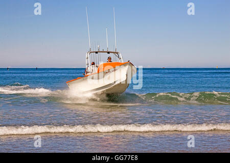 A dory boat lands on the beach at high speed in Pacific City, Oregon, home of the Pacific City Dory Fleet. Pacific City is one o Stock Photo