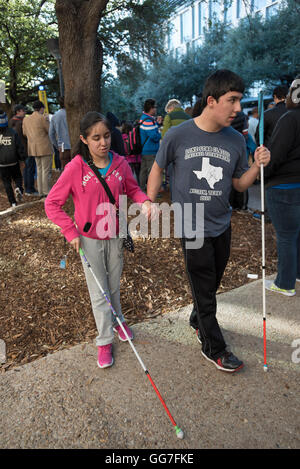 Vision-impaired students hold hands and walk with canes during Martin Luther King Day march at the University of Texas at Austin Stock Photo