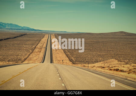 Long straight stretch of US highway 287 through ranch country in central Wyoming, USA. Retro instagram look. Stock Photo