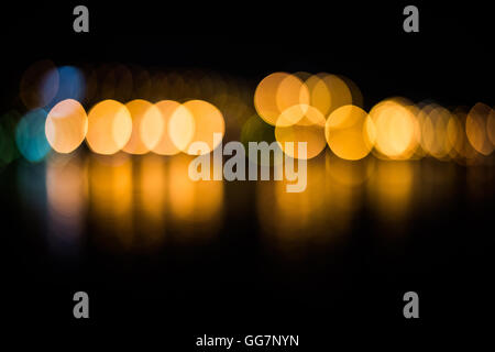 Beautiful blurred city lights with bokeh effect reflected on water background Stock Photo
