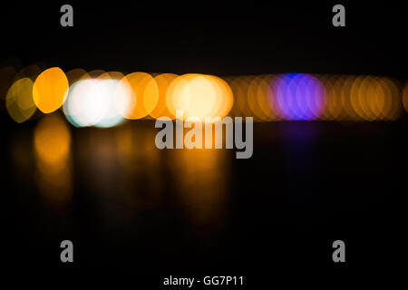 Beautiful blurred city lights with bokeh effect reflected on water background Stock Photo