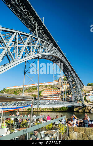 outdoor terrace bar cafe and landmark bridge in ribeira riverside area of porto portugal Stock Photo